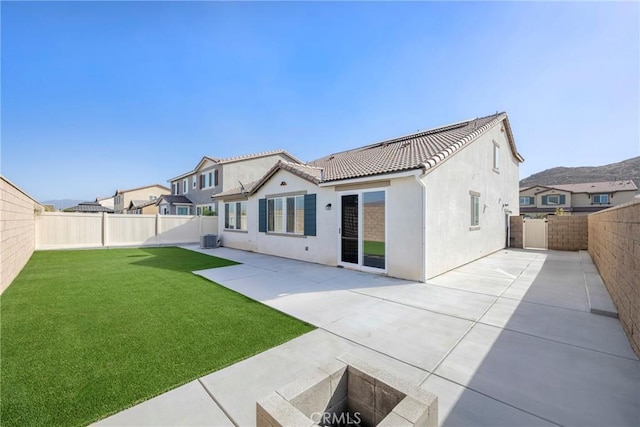 back of house with a lawn, a patio, and central air condition unit