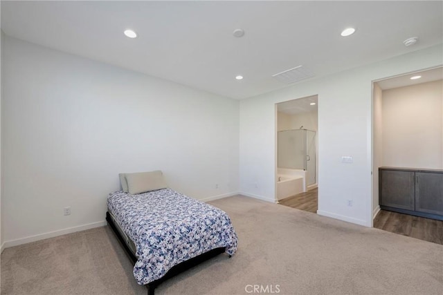 bedroom with connected bathroom and light colored carpet