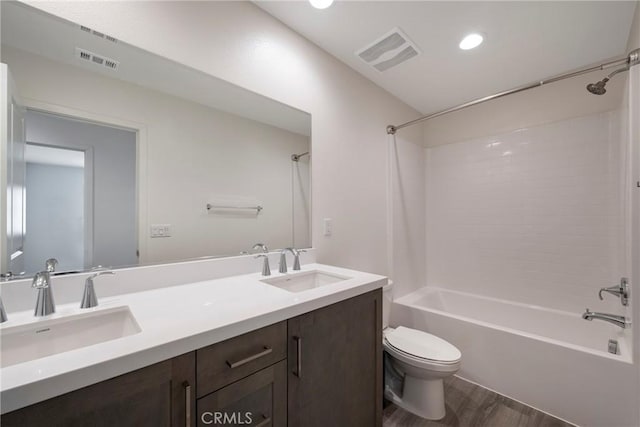 full bathroom with vanity, hardwood / wood-style flooring, shower / tub combination, and toilet