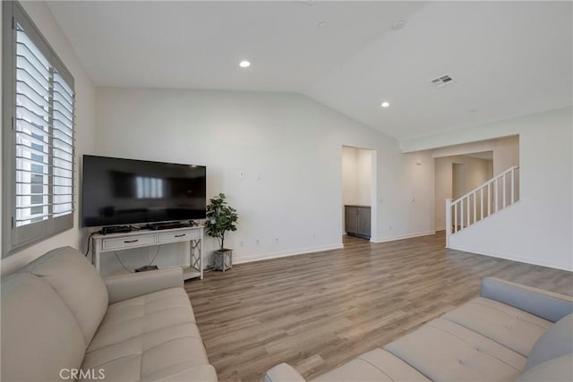 living room with light hardwood / wood-style floors and vaulted ceiling