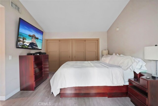 bedroom featuring lofted ceiling and light hardwood / wood-style floors