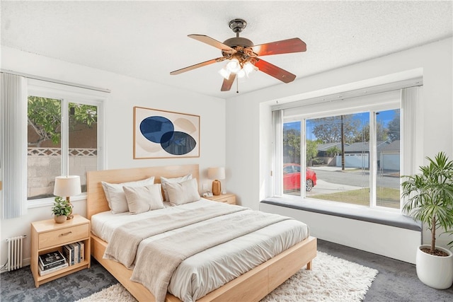 carpeted bedroom featuring radiator, a textured ceiling, ceiling fan, and access to exterior