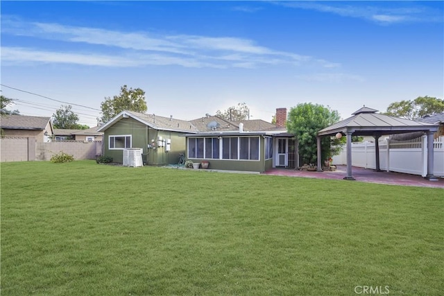 back of property with a lawn, a gazebo, a sunroom, central AC, and a patio area