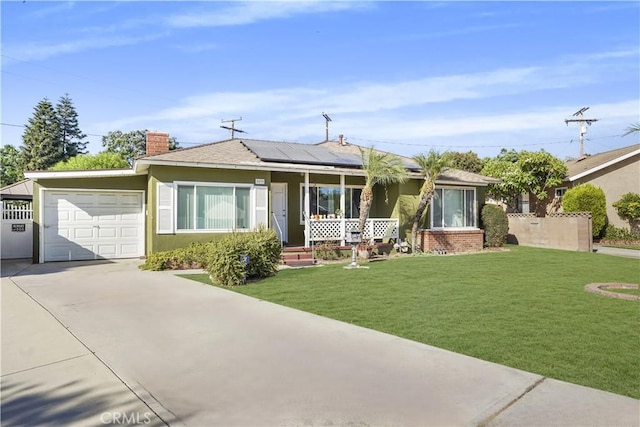 single story home featuring a garage, covered porch, a front yard, and solar panels