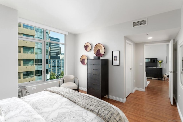 bedroom featuring multiple windows and hardwood / wood-style floors