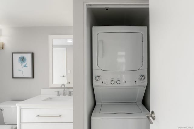 laundry area featuring sink and stacked washing maching and dryer