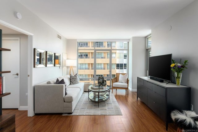 living room featuring dark hardwood / wood-style floors and a wall of windows