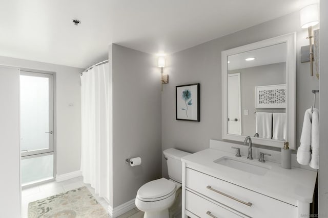 bathroom featuring vanity, toilet, and tile patterned flooring