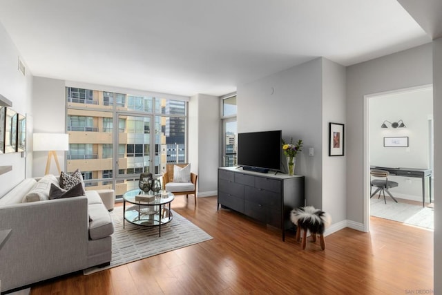 living room featuring wood-type flooring and expansive windows