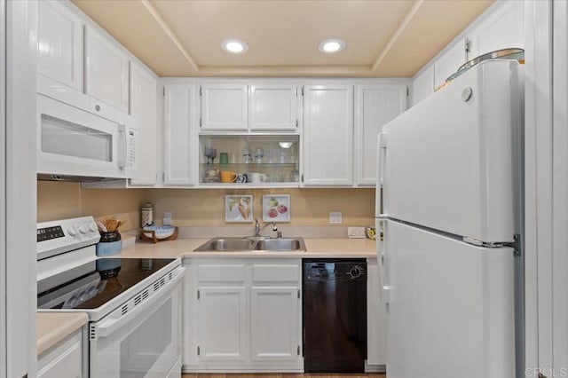 kitchen featuring white appliances, a raised ceiling, sink, and white cabinets