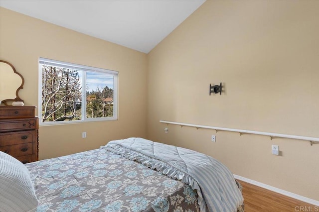 bedroom with hardwood / wood-style flooring and vaulted ceiling