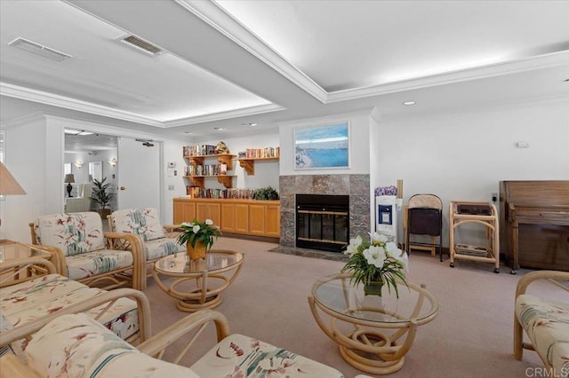 living room with light colored carpet, ornamental molding, a tray ceiling, and a tiled fireplace