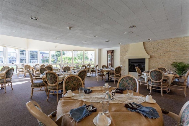 carpeted dining area with a fireplace