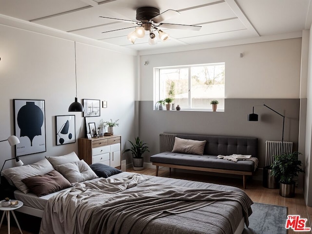 bedroom featuring ceiling fan, wood-type flooring, and radiator