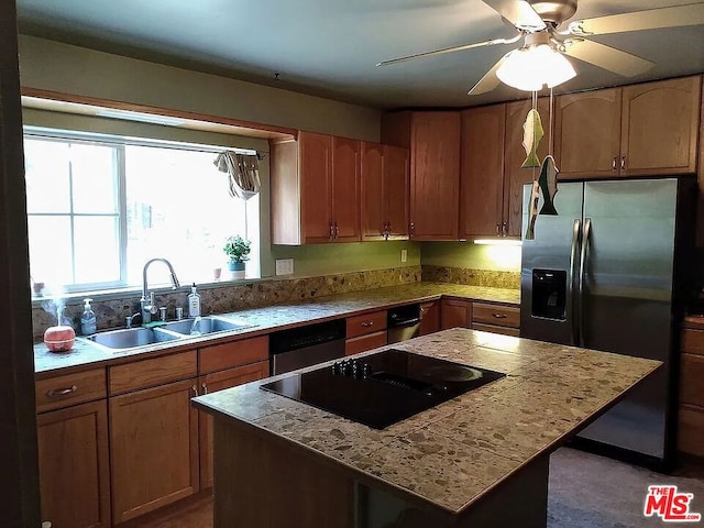 kitchen featuring ceiling fan, stainless steel appliances, sink, and a kitchen island