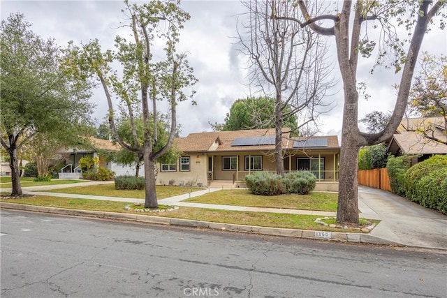 ranch-style house with a front yard and solar panels