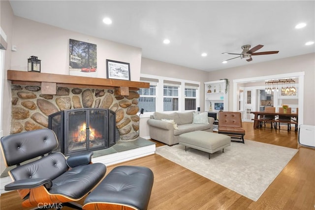 living room with ceiling fan, wood-type flooring, and a fireplace