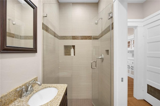 bathroom featuring a shower with door, vanity, and hardwood / wood-style floors