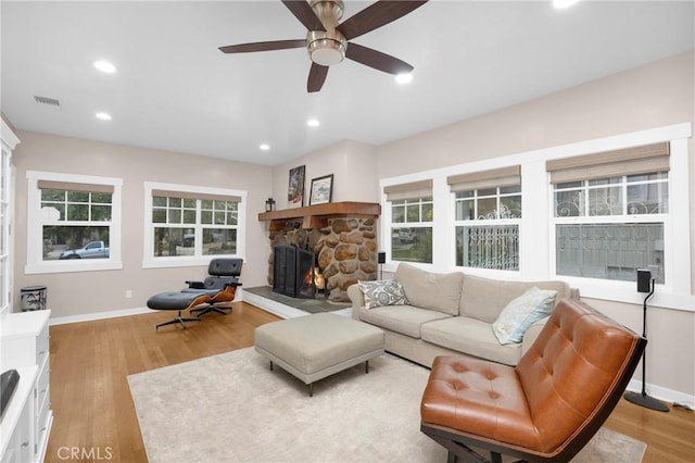 living room with light hardwood / wood-style flooring, a fireplace, and ceiling fan