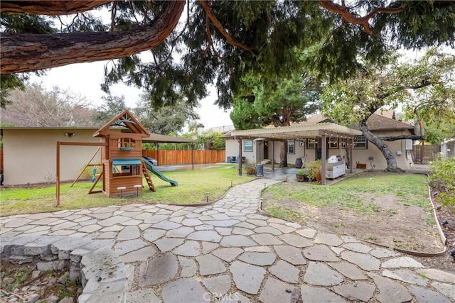 exterior space featuring a pergola, a playground, a patio area, and a lawn