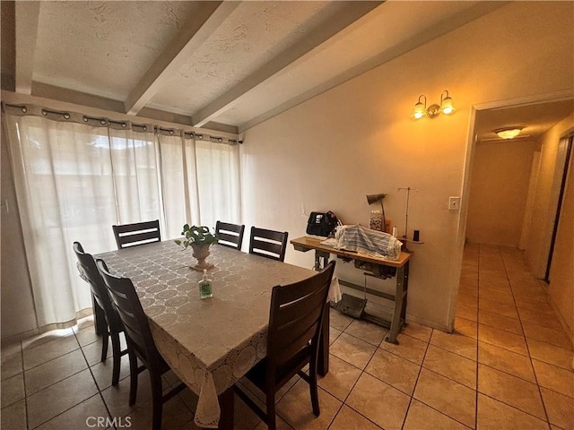 dining room featuring tile patterned flooring, a textured ceiling, and vaulted ceiling with beams