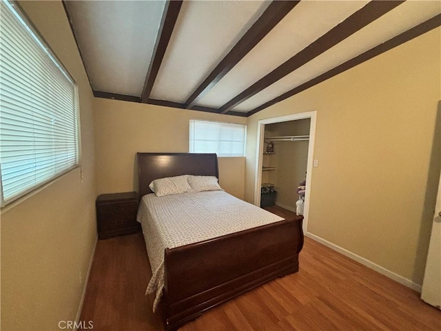 bedroom featuring lofted ceiling with beams, hardwood / wood-style floors, and a closet