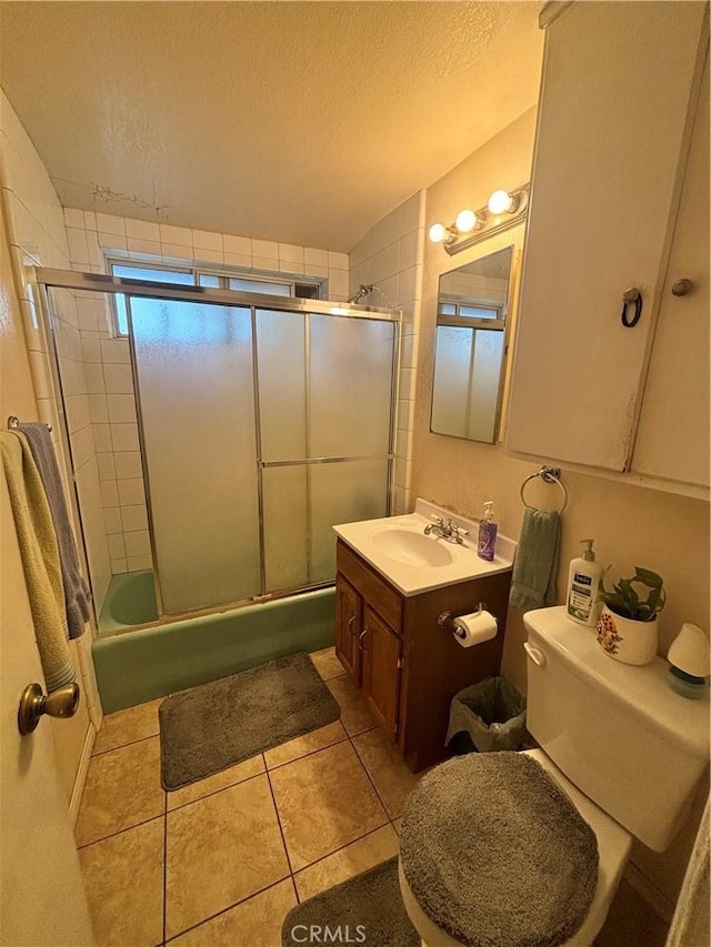 bathroom featuring tile patterned floors, vanity, toilet, and a textured ceiling