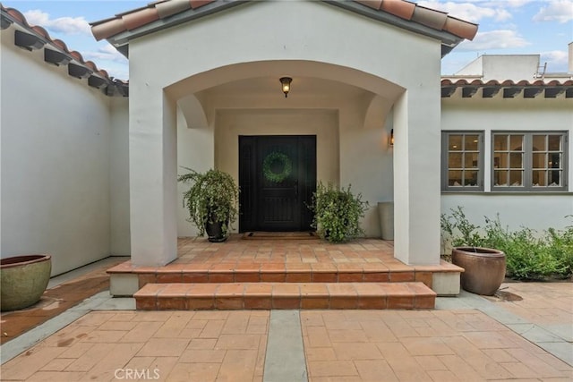 view of exterior entry with a patio area