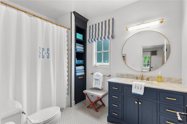 bathroom featuring vanity, tile patterned flooring, and toilet