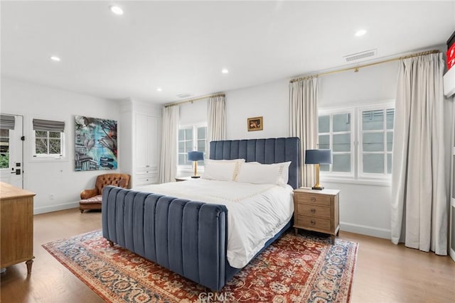 bedroom featuring multiple windows and light hardwood / wood-style floors