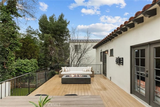 wooden terrace with an outdoor living space with a fire pit