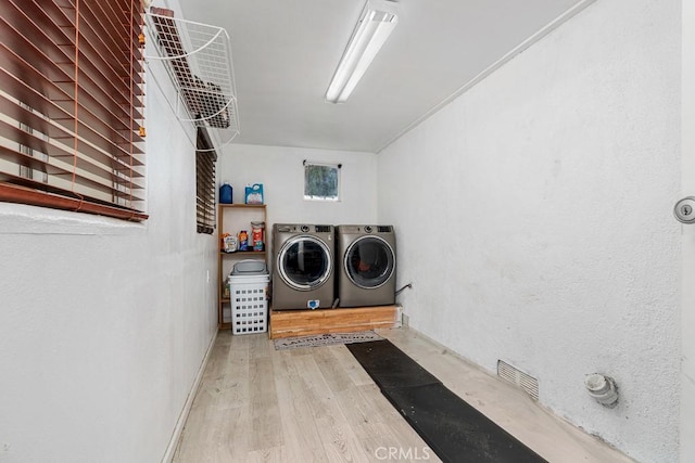 washroom featuring hardwood / wood-style floors and washing machine and clothes dryer