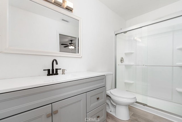 bathroom with vanity, toilet, an enclosed shower, and hardwood / wood-style floors