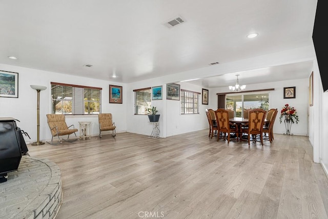 interior space featuring an inviting chandelier, a wealth of natural light, and light wood-type flooring