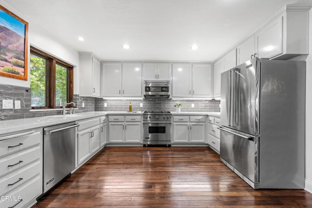 kitchen featuring white cabinetry, high quality appliances, dark wood-type flooring, and light stone counters