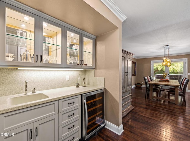 bar with crown molding, wine cooler, indoor wet bar, and a sink