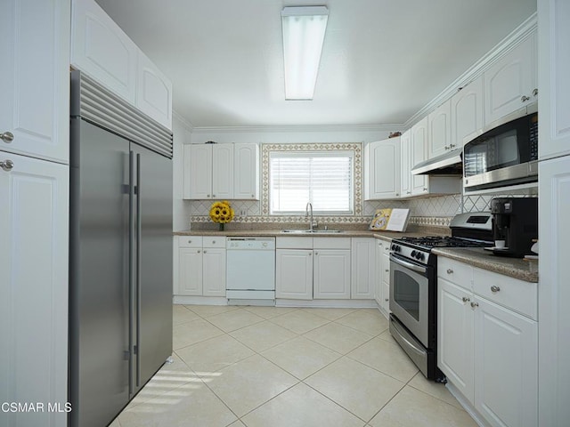 kitchen featuring white cabinetry, sink, decorative backsplash, light tile patterned floors, and stainless steel appliances