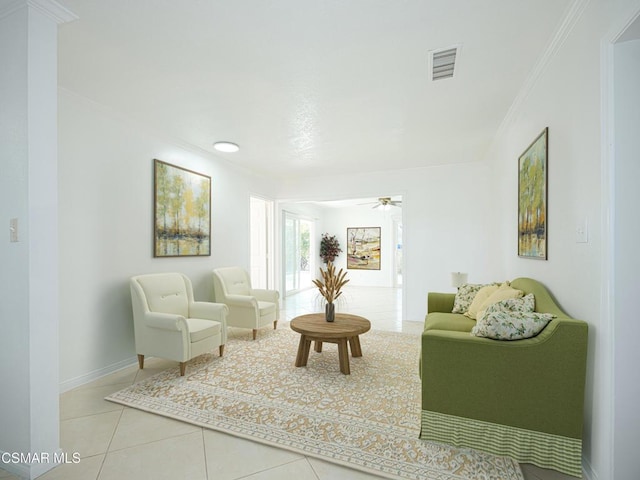 living area with tile patterned flooring, crown molding, and ceiling fan