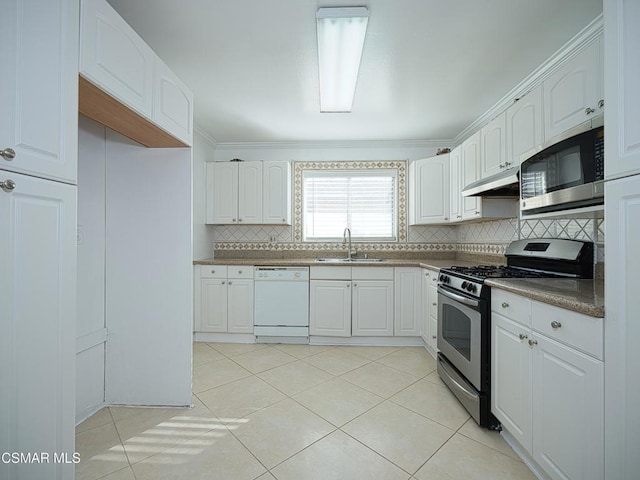 kitchen with sink, light tile patterned floors, white cabinetry, stainless steel appliances, and decorative backsplash