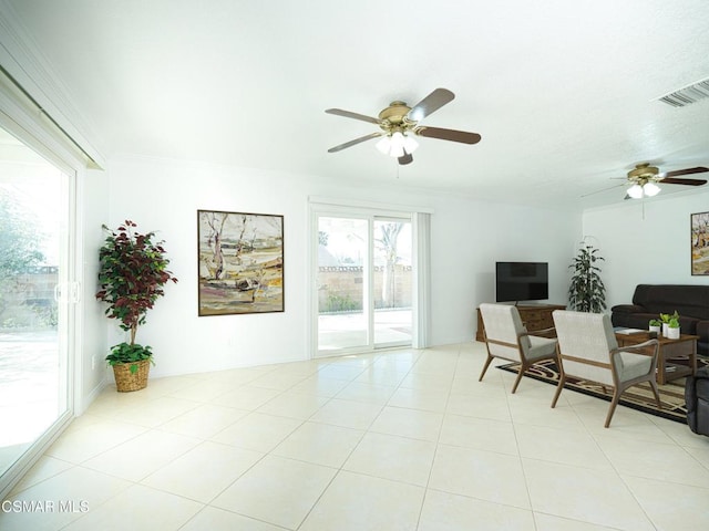 living room with ceiling fan, ornamental molding, and light tile patterned floors