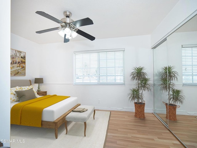 bedroom with hardwood / wood-style flooring, ceiling fan, and a closet