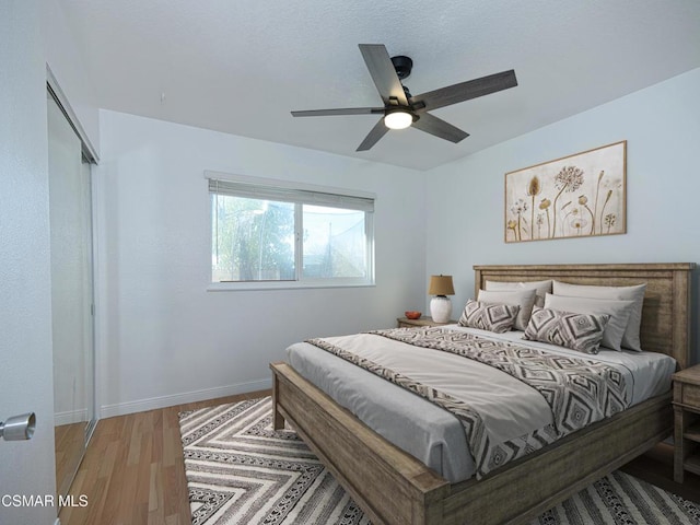 bedroom featuring hardwood / wood-style floors, ceiling fan, and a closet