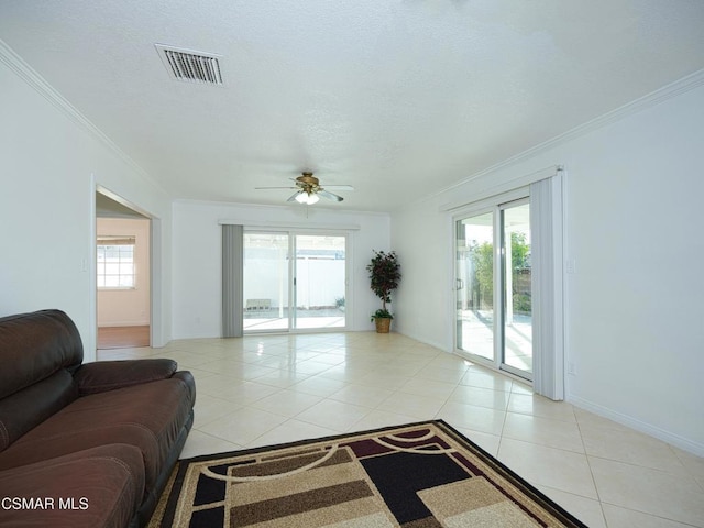 living room with light tile patterned floors, ornamental molding, a healthy amount of sunlight, and ceiling fan