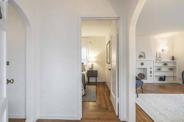 corridor with wood-type flooring and built in features