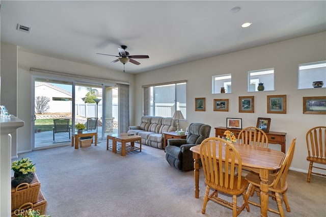 dining space featuring light carpet and ceiling fan