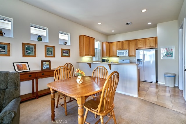 dining area featuring light carpet