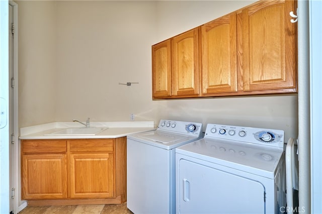 laundry area featuring sink, washing machine and dryer, and cabinets