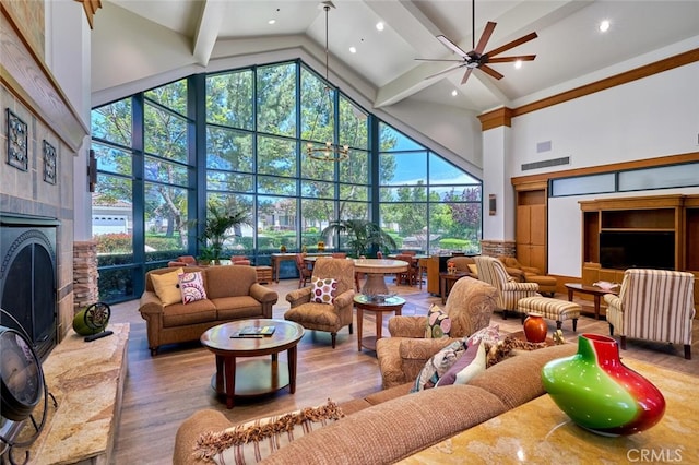 living room featuring wood-type flooring, ceiling fan, and a high ceiling