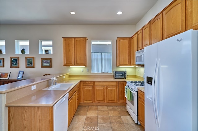 kitchen with sink, white appliances, and kitchen peninsula