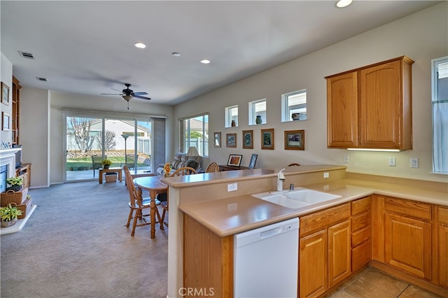 kitchen featuring sink, light carpet, white dishwasher, kitchen peninsula, and ceiling fan